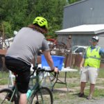 Volunteer offering water to passing bikers