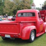 The rear side of a classic Ford Truck painted in bright red