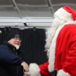 Walt Lindala greets Santa as he takes the stage